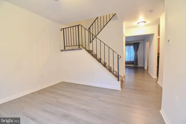 a view of a hallway with wooden floor and entryway