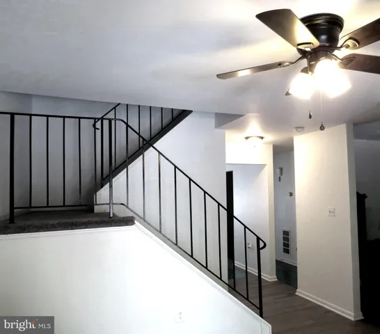 a view of staircase with railing and white walls