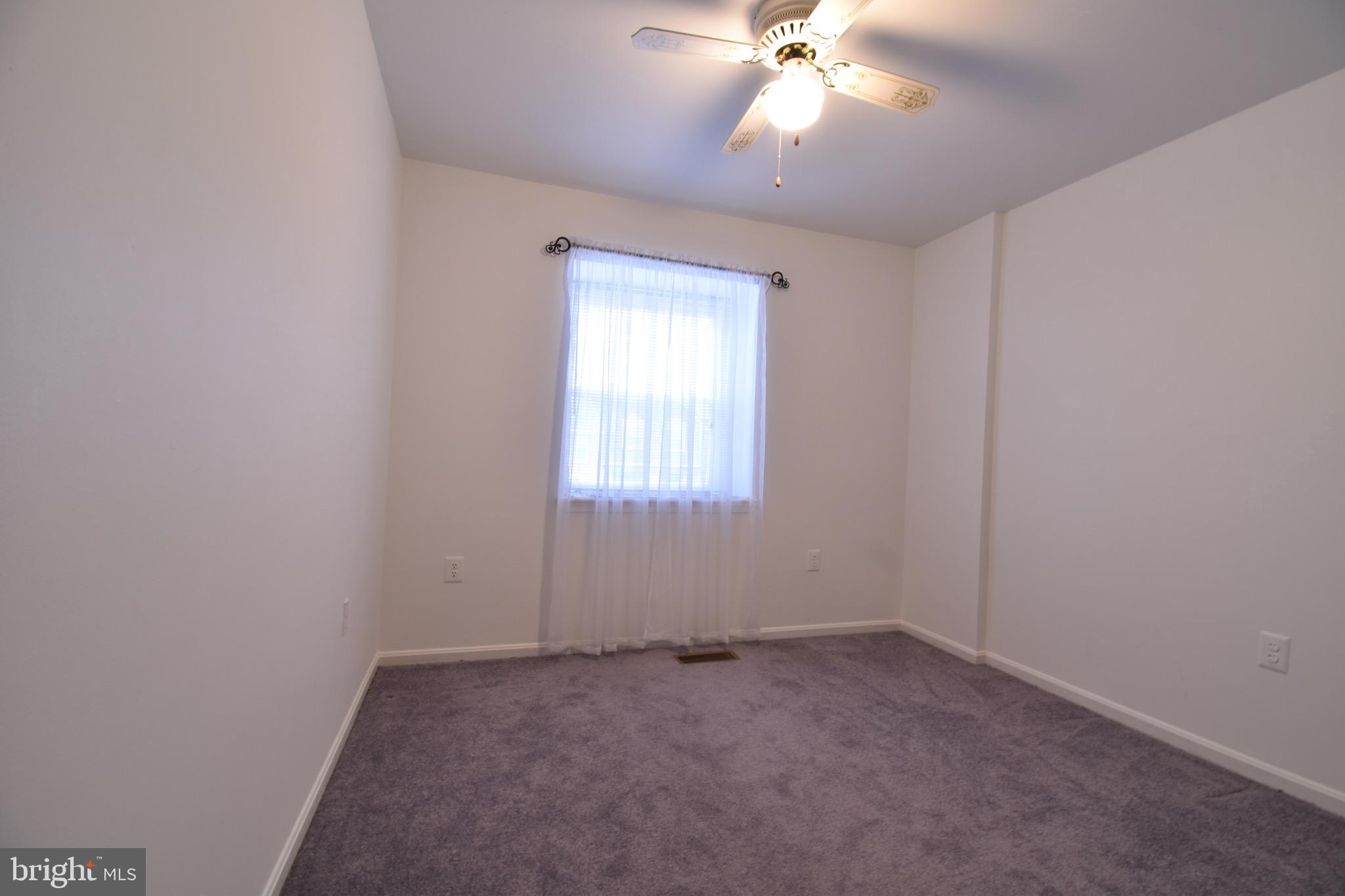 7730 Merrick Lane Landover, MD 20785 - Photo 7 of 19 an empty room with a chandelier fan and windows