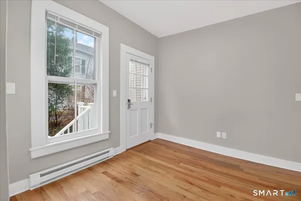 an empty room with wooden floor and windows