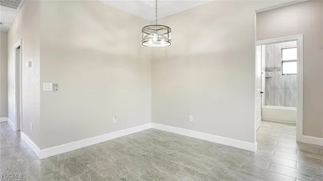 a view of empty room with window and wooden floor