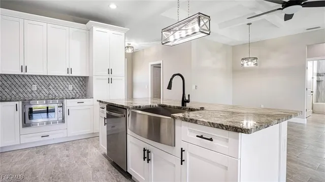 a view of a kitchen with a sink and chandelier