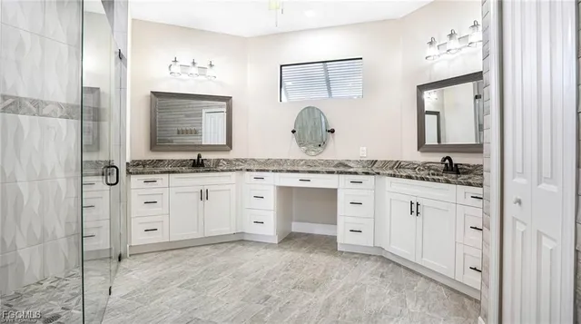 a spacious bathroom with a granite countertop sink and a mirror
