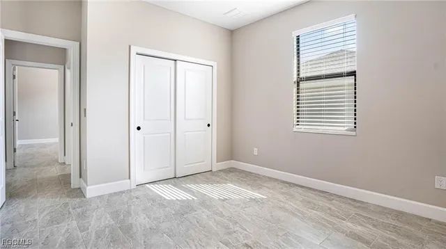 an empty room with windows and closet
