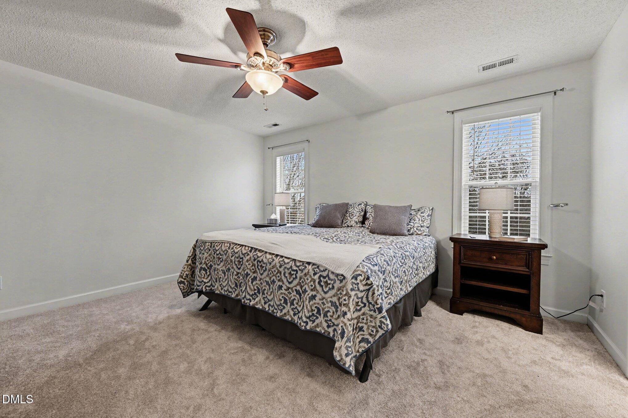 205 Weathervane Way Holly Springs, NC 27540 - Photo 9 of 25 a bedroom with a bed chandelier and a window