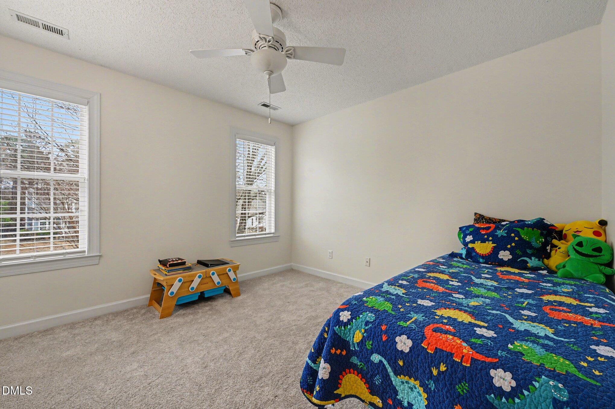 205 Weathervane Way Holly Springs, NC 27540 - Photo 12 of 25 a bedroom with a bed and a dresser in it
