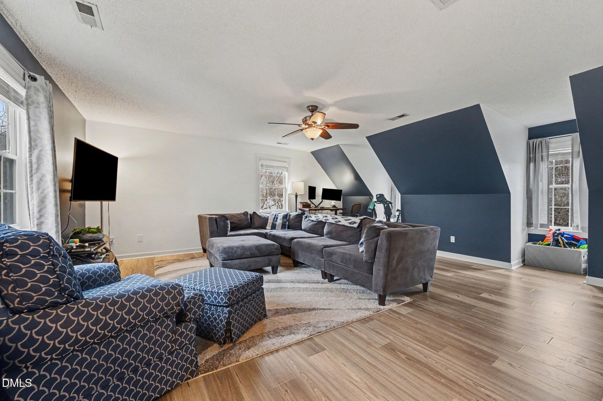 205 Weathervane Way Holly Springs, NC 27540 - Photo 17 of 25 a living room with furniture and a flat screen tv