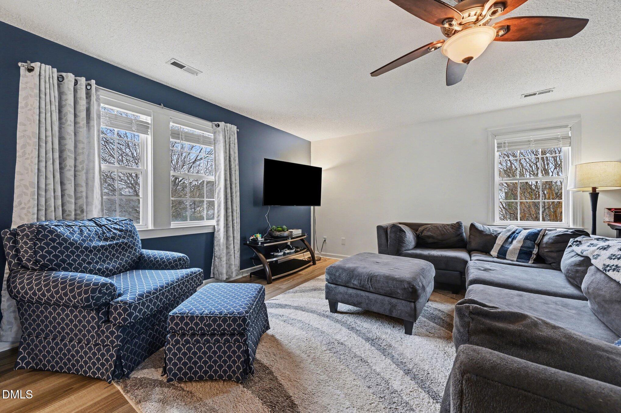 205 Weathervane Way Holly Springs, NC 27540 - Photo 18 of 25 a living room with furniture and a flat screen tv