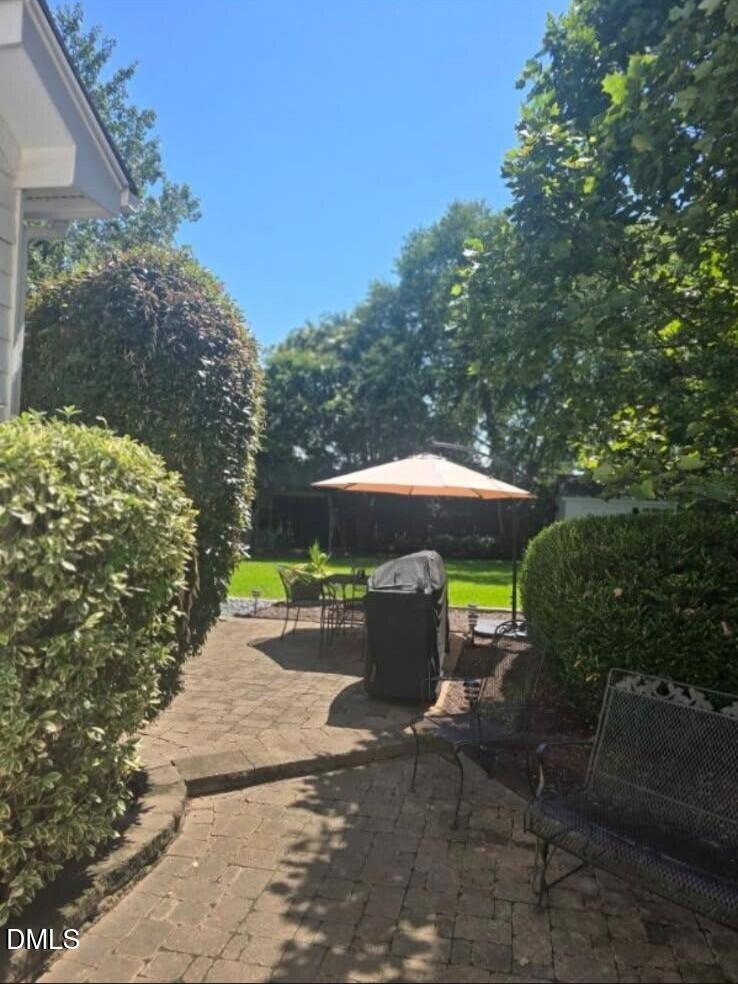 205 Weathervane Way Holly Springs, NC 27540 - Photo 23 of 25 a view of a patio with table and chairs under an umbrella
