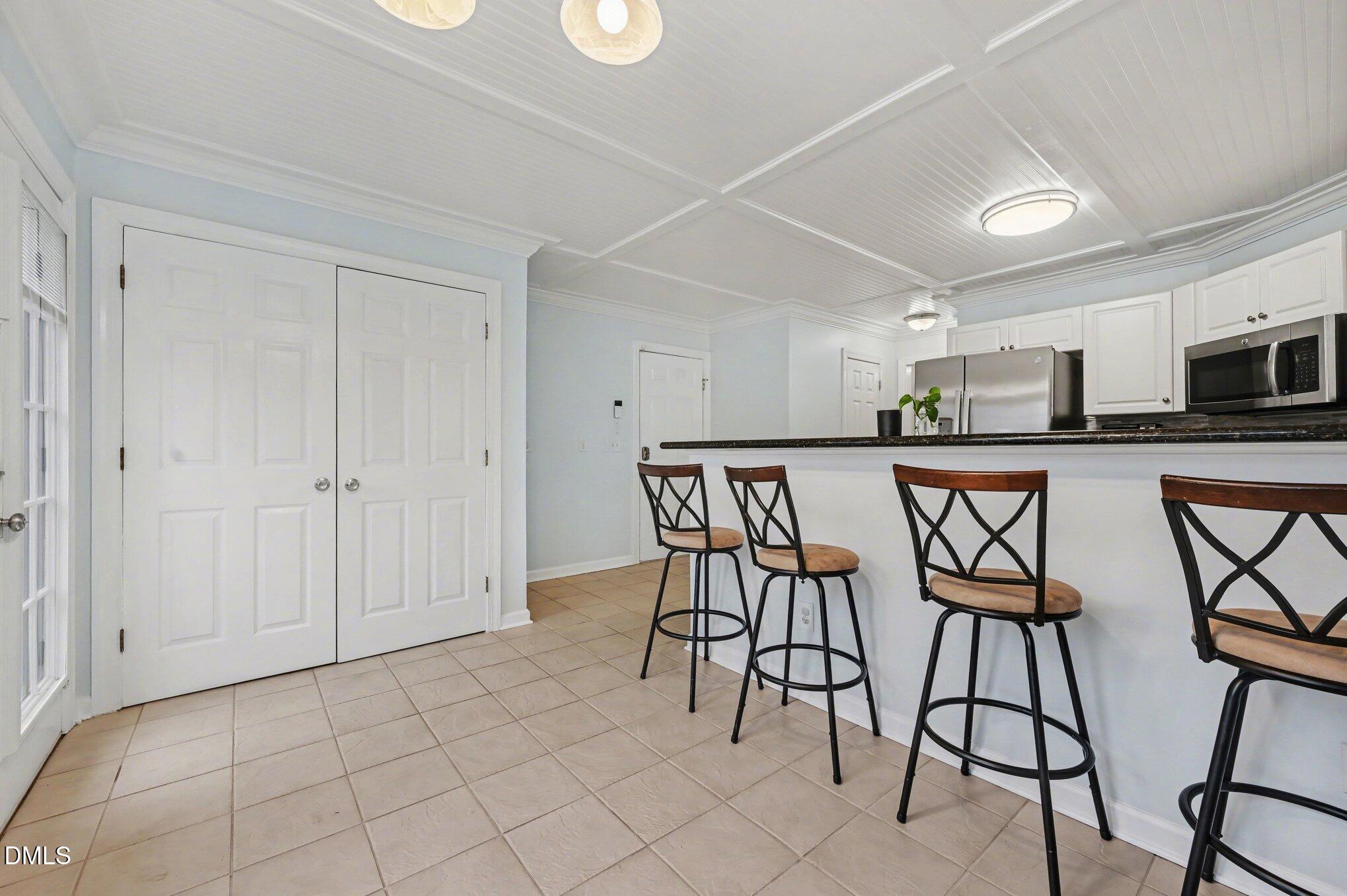 205 Weathervane Way Holly Springs, NC 27540 - Photo 7 of 25 a kitchen with stainless steel appliances a table chairs refrigerator and microwave