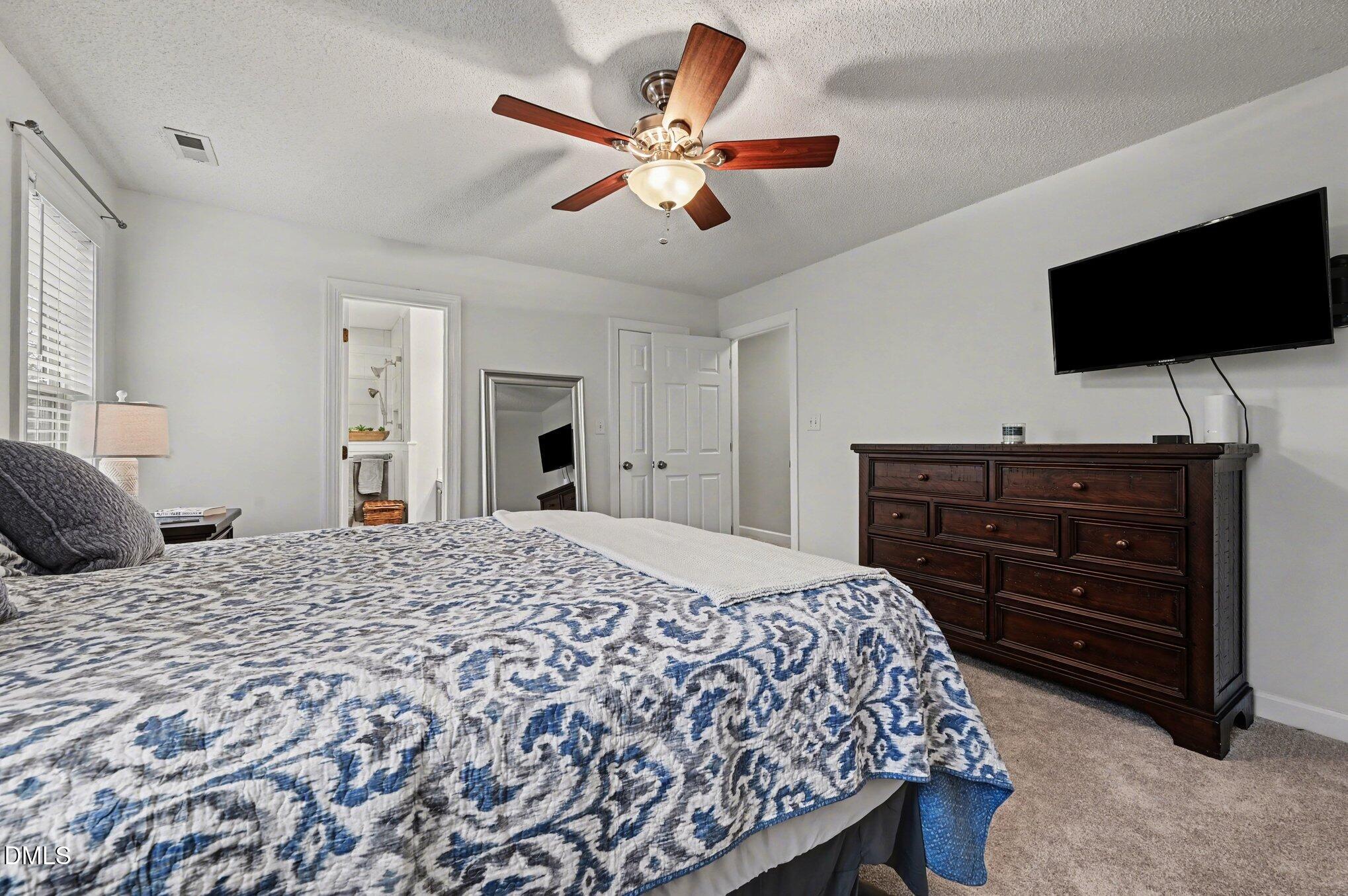 205 Weathervane Way Holly Springs, NC 27540 - Photo 8 of 25 a bedroom with a bed and a flat screen tv