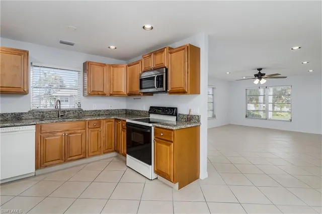 a kitchen with stainless steel appliances granite countertop a stove a sink and a microwave