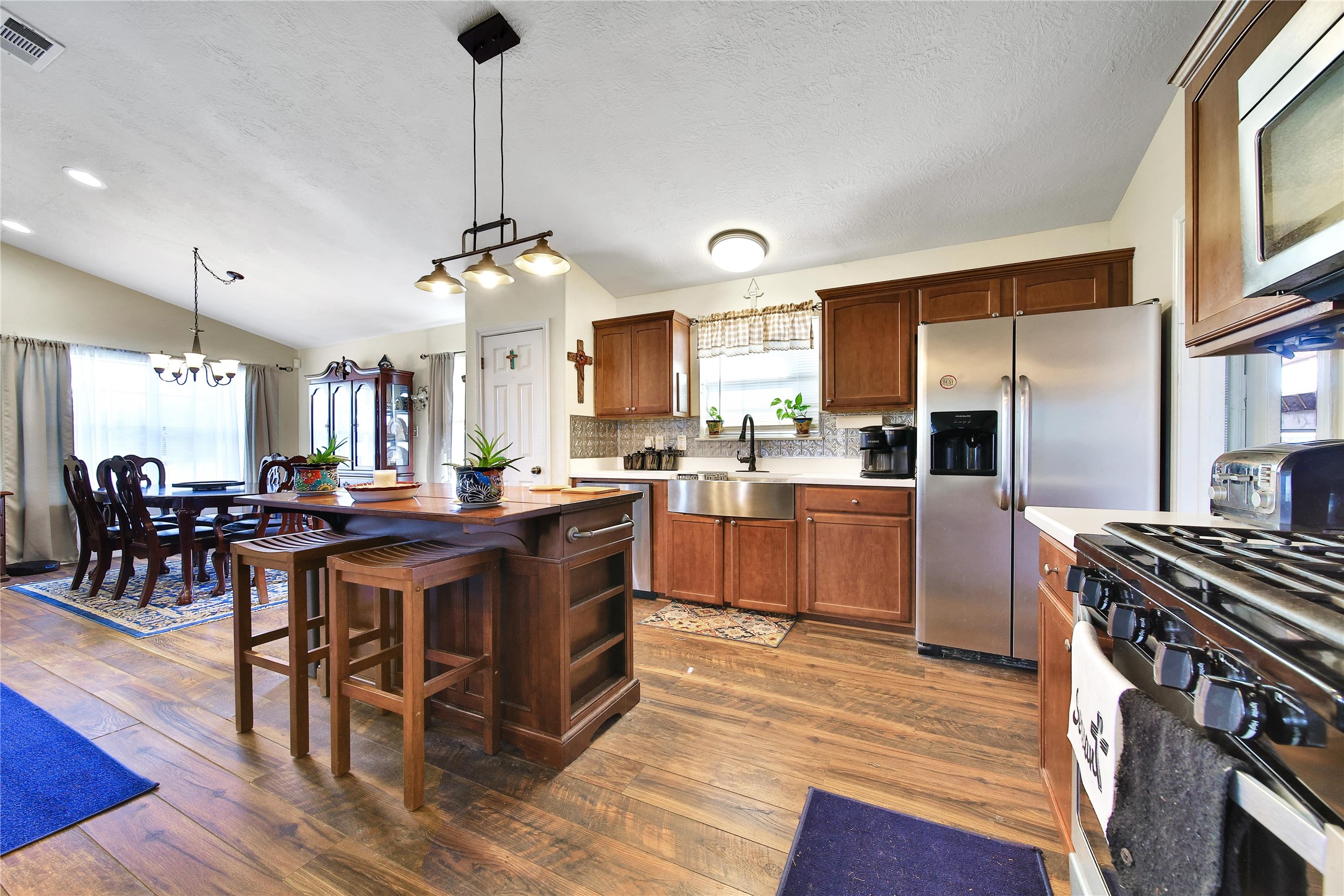 6151 West Creek Road East Bernard, TX 77435 - Photo 26 of 48 a kitchen with stainless steel appliances granite countertop a stove a refrigerator a sink a dining table and chairs with wooden floor