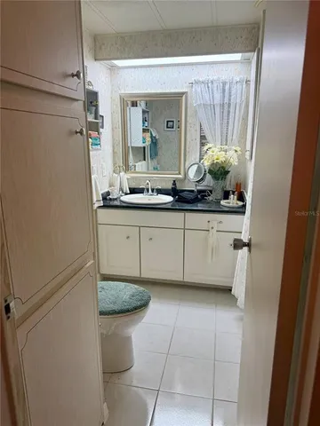 a bathroom with a granite countertop sink a toilet and a mirror