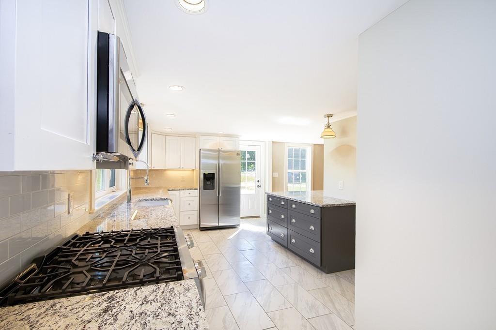 128 Washington Street, Unit R Hanover, MA 02339 - Photo 11 of 29 a kitchen with a refrigerator a stove a sink and a counter top