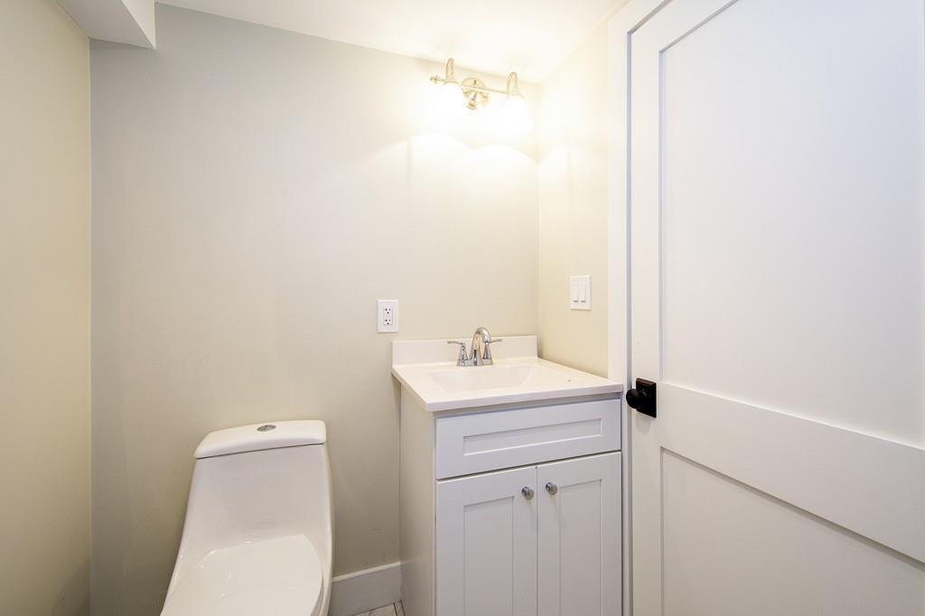128 Washington Street, Unit R Hanover, MA 02339 - Photo 14 of 29 a bathroom with a sink a toilet and a mirror