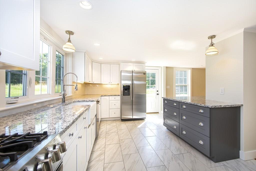 128 Washington Street, Unit R Hanover, MA 02339 - Photo 9 of 29 a kitchen with granite countertop a refrigerator and a sink