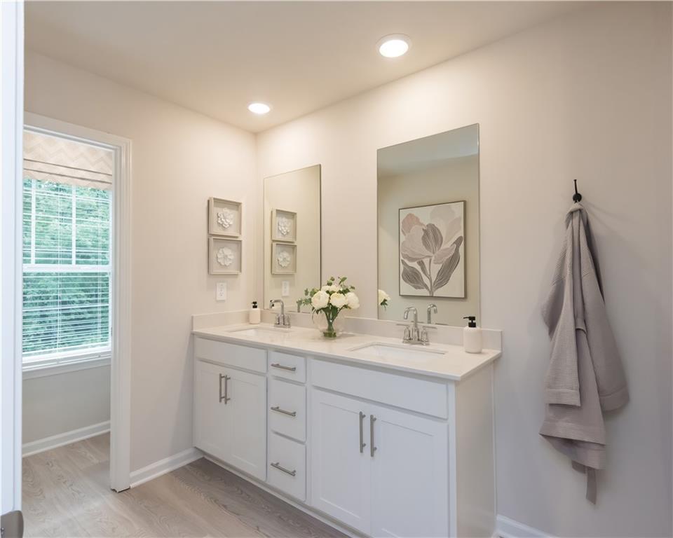 2246 Ashton Drive Conyers, GA 30013 - Photo 11 of 18 a bathroom with double vanity sink a two mirror a window and a bathtub