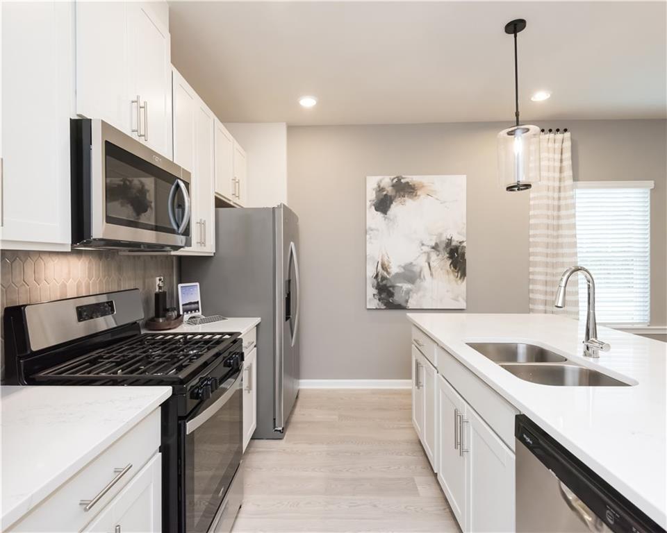 2246 Ashton Drive Conyers, GA 30013 - Photo 5 of 18 a kitchen with stainless steel appliances granite countertop a sink stove and refrigerator