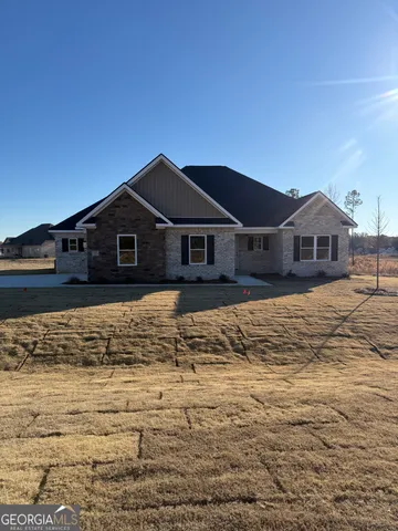 a large pool is sitting in front of a house with a yard