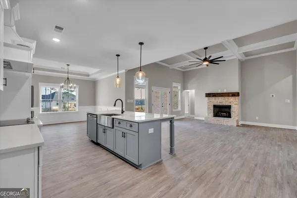 a kitchen with kitchen island stainless steel appliances a sink stove and wooden floor
