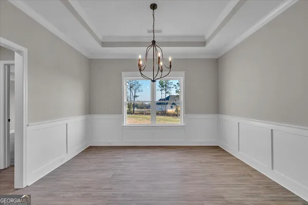 a view of an empty room with kitchen and a window