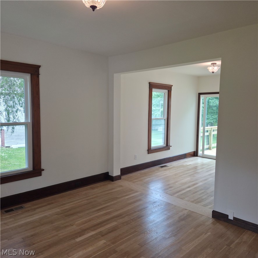9964 East River Road Elyria, OH 44035 - Photo 11 of 45 Hardwood flooring throughout featuring a unique wood inlay detail, white walls, and dark wood trim