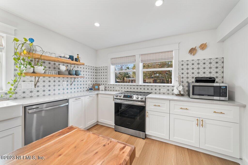 469 Skate Road Atlantic Beach, FL 32233 - Photo 17 of 40 a kitchen with stainless steel appliances granite countertop a stove and white cabinets