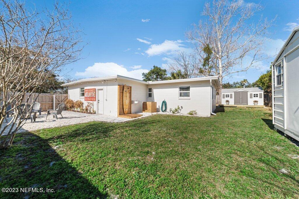 469 Skate Road Atlantic Beach, FL 32233 - Photo 35 of 40 a view of a white house in front of a big yard with large trees plants and large tree