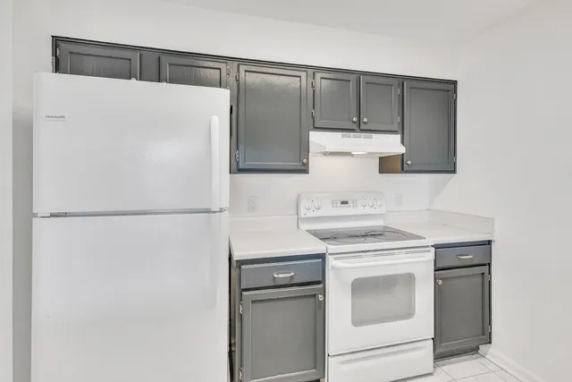 a white refrigerator freezer and a stove sitting inside of a kitchen