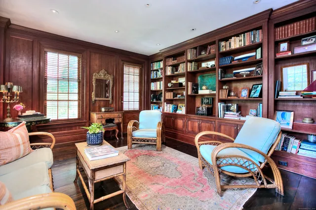 a living room with furniture a bookshelf and a large window