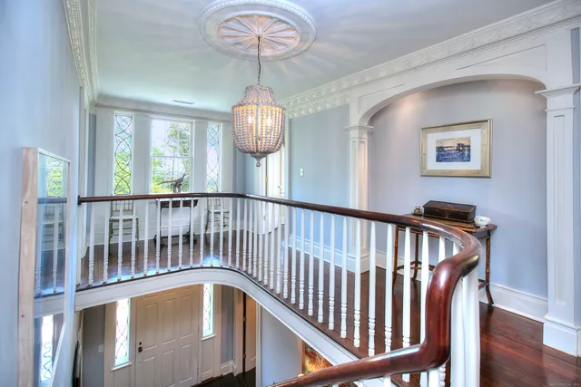a view of a hallway with wooden floor and chandelier