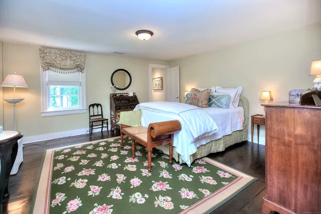 a bedroom with a bed and dresser with mirror