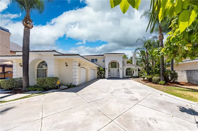a view of a white house with a yard and table and chairs under an umbrella
