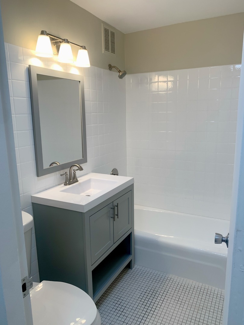 655 West Irving Park Road, Unit 1505 Chicago, IL 60613 - Photo 12 of 23 a bathroom with a sink mirror vanity and toilet
