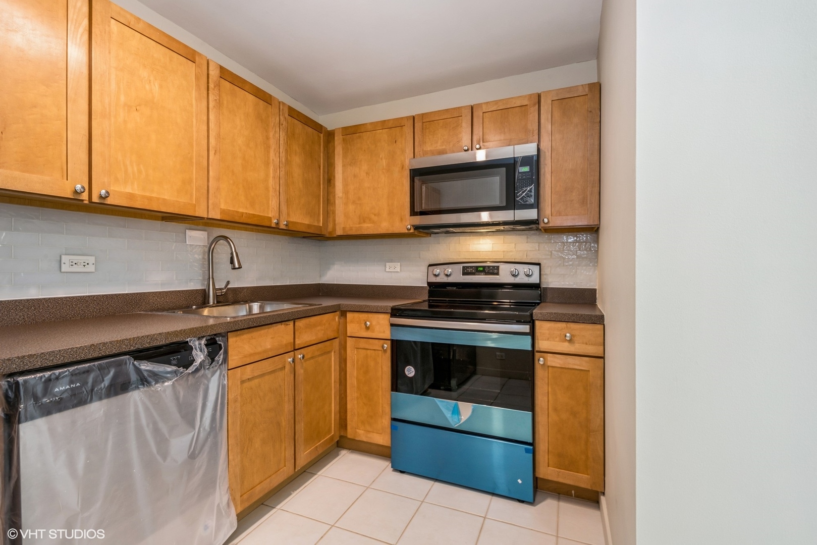 655 West Irving Park Road, Unit 1505 Chicago, IL 60613 - Photo 14 of 23 a kitchen with stainless steel appliances granite countertop a stove and a microwave