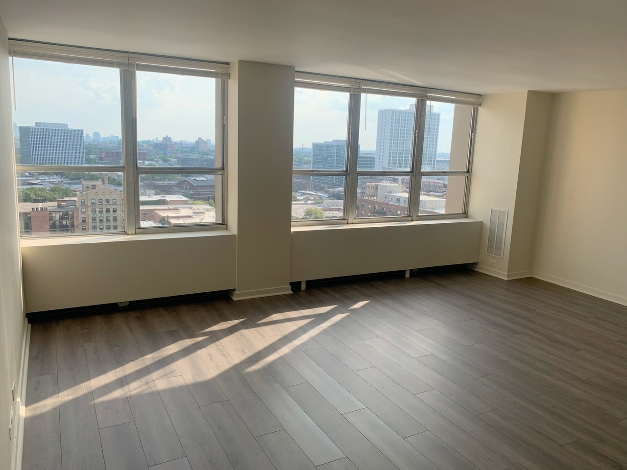 655 West Irving Park Road, Unit 1505 Chicago, IL 60613 - Photo 15 of 23 a view of an empty room with wooden floor and a window