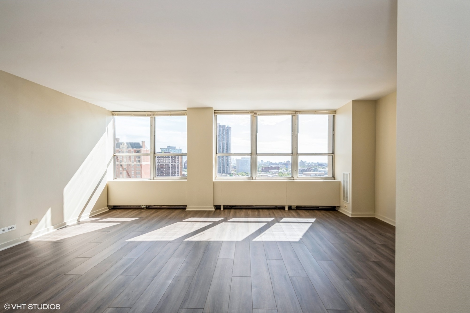 655 West Irving Park Road, Unit 1505 Chicago, IL 60613 - Photo 6 of 23 an empty room with wooden floor and windows