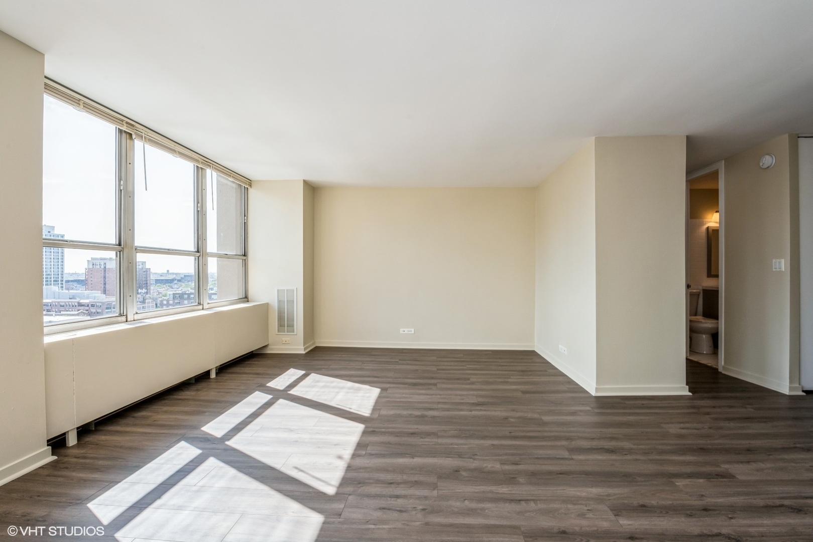 655 West Irving Park Road, Unit 1505 Chicago, IL 60613 - Photo 9 of 23 a view of an empty room with wooden floor and a window
