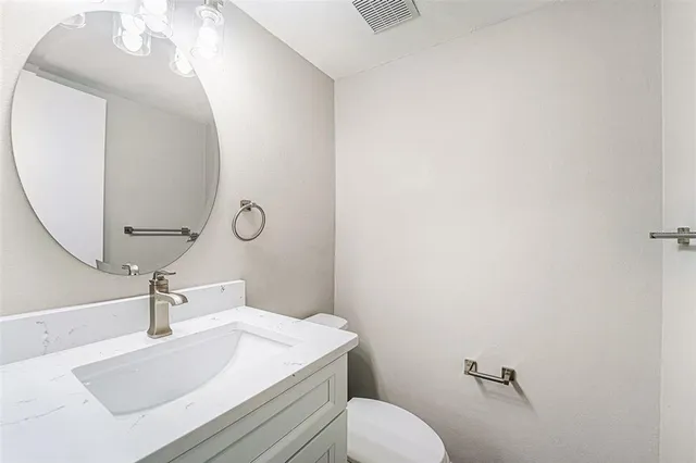 a bathroom with a sink a toilet and mirror