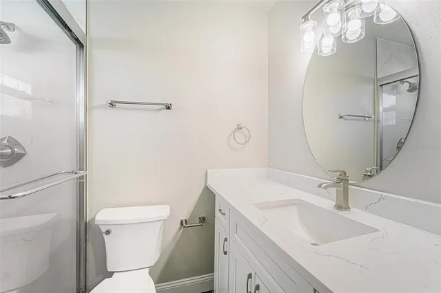 a bathroom with a sink toilet vanity and shower