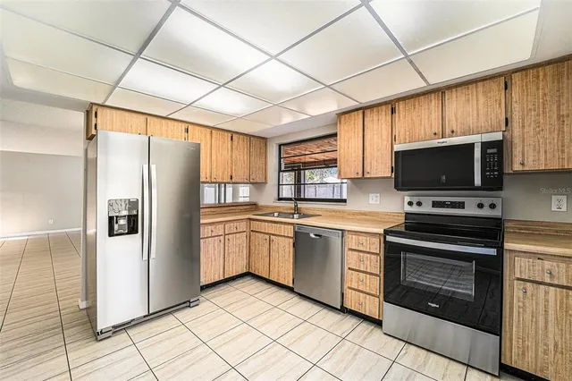 a kitchen with stainless steel appliances granite countertop a refrigerator and a stove top oven