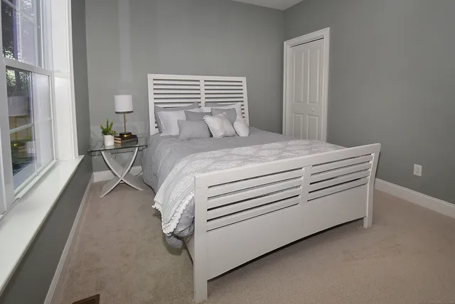 a bedroom with a bed and a large window