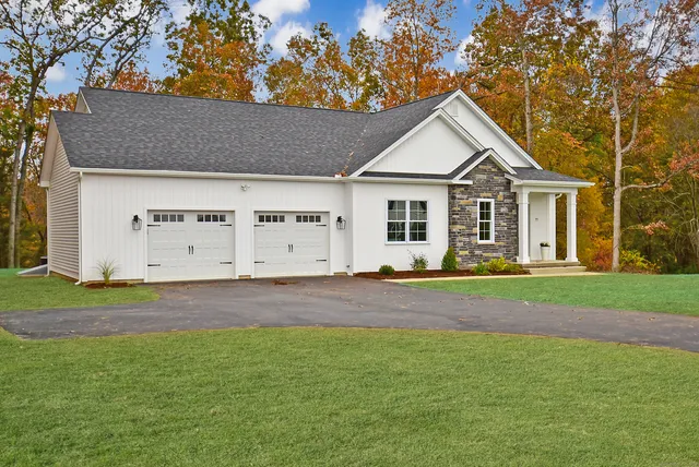 a view of a house with a yard and large tree