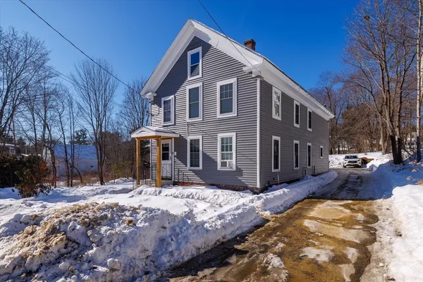 a front view of a house with a yard covered in snow