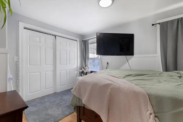 a bedroom with a bed and a flat screen tv