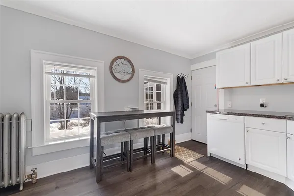 a kitchen with a table chairs refrigerator and cabinets