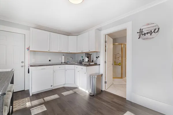 a kitchen with granite countertop white cabinets and white appliances