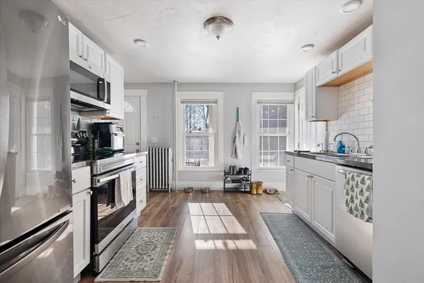 a large kitchen with a large window and stainless steel appliances