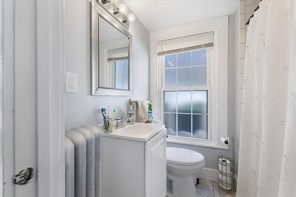 a bathroom with a toilet sink vanity and mirror